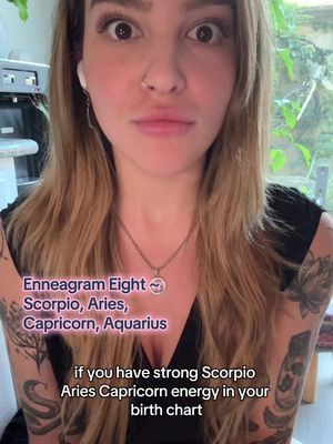 The cover image features a woman in a close-up shot, looking directly at the camera with a neutral expression and wide eyes. She has long, wavy blonde hair and is wearing earrings and a necklace. The background is somewhat blurred, suggesting an indoor setting with a window. Text overlays with a pinkish hue are added to the image, listing astrological signs and the words "Enneagram Eight."