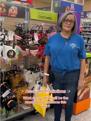 The cover image features a woman standing in front of a display of dog and cat costumes. She is wearing a blue shirt and jeans. The display is colorful and includes a variety of costumes. The overall composition is bright and inviting.