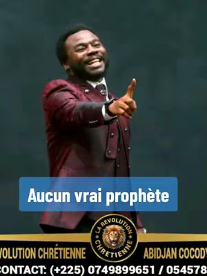 The image features a smiling Black man in a maroon suit, pointing upwards. The background is a dark, undefined color. Text overlayed in a blue rectangle says, "Aucun vrai prophète". A gold and black emblem for a Christian organization is at the bottom of the image, with additional text.