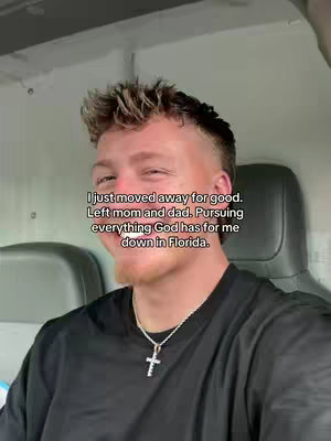 The cover image shows a young man in a vehicle, with text overlaid. He has short, textured blonde hair, a trimmed beard, and is wearing a black t-shirt and a silver cross necklace. The background is a lightly colored interior, possibly of a vehicle or enclosed space.
