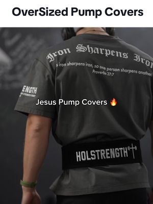 The image shows a person from the back wearing a dark gray t-shirt and a weightlifting belt. The t-shirt has the text "Iron sharpens Iron" with biblical verse on it, and the belt says "HOLSTRENGTH" with a cross. The overall shot focuses on the back of the person while they are in a gym setting.