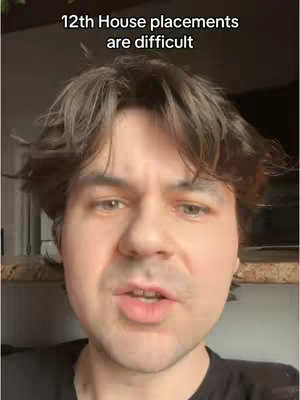 A man with brown hair is talking to the camera. He is wearing a black shirt, and there is text on the upper part of the screen.