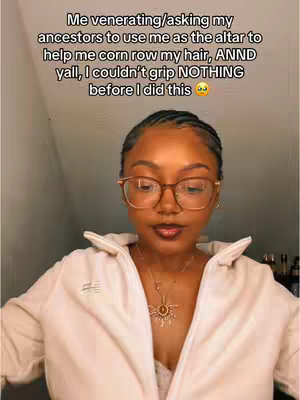 A selfie-style shot with a Black woman at center, framed from the chest up. She is wearing glasses and a light-colored, open collared shirt. Her hair is styled in cornrows. Text is overlaid at the top.