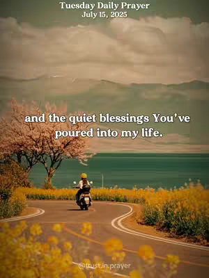 A scenic view of a winding road with a yellow-flowered median. A person on a motorcycle is driving away from the viewer. In the background, mountains can be seen, with vibrant green water. The sky is cloudy and muted, and overlaid at the top are the words Tuesday Daily Prayer, July 15, 2025, and another quote on the center. The bottom of the video has a user handle overlaid.
