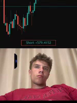 A young man in a red shirt looks up pensively, with an overlay of a stock chart showing red and green bars and text that reads 'Short +579.4152'. A floating black phone with a blue X is also present.