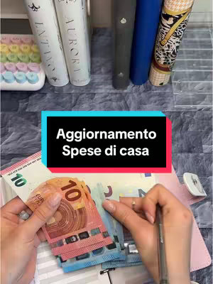 The cover photo displays a collection of items related to budgeting and finance. At the bottom, a pair of hands are holding and organizing a stack of Euro banknotes. Above, there's a rectangle with a text overlay. In the background, there are books, a colorful keyboard, and a light, textured surface.