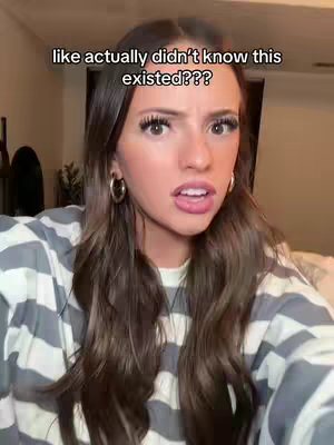 A close-up shot of a young woman. She has long brown hair and is wearing gold hoop earrings. She has wide eyes, and her mouth is slightly open. The background appears to be a room, and a text overlay is across the top of the image.
