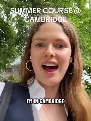 A young woman with long brown hair and hoop earrings looks directly at the camera with an open mouth. She appears to be speaking. Behind her is a blurred background of green trees. Text overlays at the top and bottom of the image.