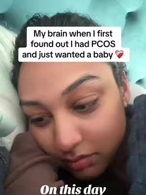 The cover image is a close-up shot of a person lying down, looking at the camera with a somber expression. Above their head, a text box reads: 'My brain when I first found out I had PCOS and just wanted a baby 💖'. The background is out of focus, suggesting the person is in bed or a similar setting. The lighting is soft.