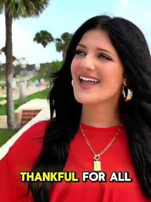 The cover image features a woman with long, dark hair and a red top, smiling and looking upwards. The background is blurred, suggesting an outdoor setting. Text overlay reads 'THANKFUL FOR ALL'.