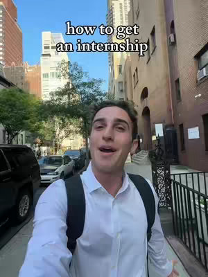 A man stands on a city sidewalk in front of buildings, appearing to be vlogging or recording a video. Text overlaid on the image reads "how to get an internship."