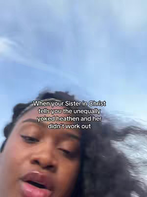 A close-up shot of a Black woman with curly hair, looking at the camera with a slightly open mouth. Text is overlaid at the top, and a cloudy sky forms the background.