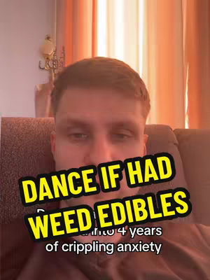 A selfie-style video with a man looking down, overlaid with text in a yellow box, indicating a personal experience with anxiety and weed edibles. The background is blurred, showing a room with curtains.