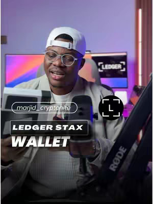 A man wearing glasses and a white cap is holding up a black and white ledger wallet. There is text overlay on the image.