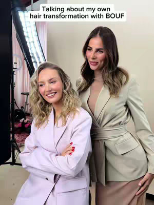The cover image shows two women, both in blazers, posing in what appears to be a studio setting. The woman on the left is smiling and wearing a light pink blazer. The woman on the right is wearing a beige blazer and a more neutral expression. Behind them is a light, possibly pink, backdrop.