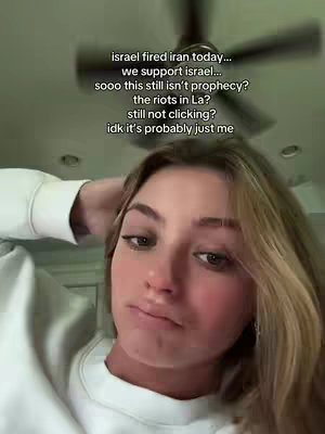 A young woman with blonde hair and a white sweater is looking at the camera with a slightly concerned expression. Text overlays are present on the upper part of the image.
