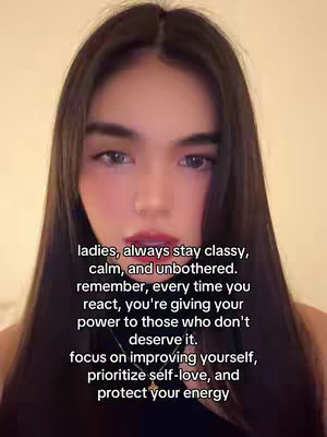A selfie-style image featuring a woman. She has long, dark hair framing her face. She is looking toward the camera. Overlayed text with a white font is visible over parts of her face and the background.