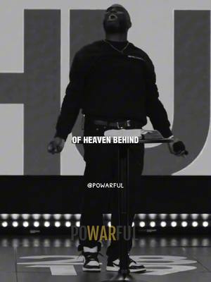 A black and white image features a man standing at a podium, looking up with an open mouth as if speaking passionately. Text overlays read 'OF HEAVEN BEHIND' mid-image and '@POWARFUL' near the bottom. The background is a large, blurred stage setup, and the lighting is focused on the man. The man is dressed in black clothing.