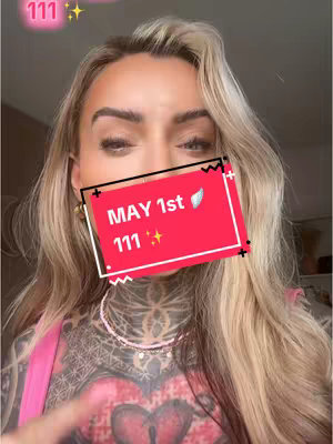 A woman's face close-up with visible tattoos is seen. A red square with white text overlays her face, with the text 'MAY 1st' and '111', along with a wing symbol. The background is a simple, indistinct interior.
