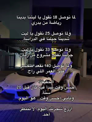 The image is a vertical shot featuring a car in a street setting at night. It has text overlays in Arabic, conveying motivational messages against the backdrop of the car and a person. The composition highlights a luxury car, possibly a Lamborghini, in a dark environment, with the car's doors open. The text uses contrast, with white text on a dark background, for emphasis.