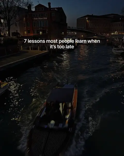A nighttime shot of a canal in Venice with buildings lining the sides and a boat moving through the water with text overlayed on top.
