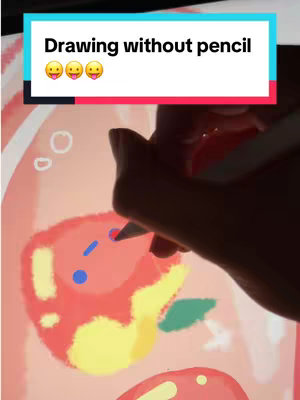 The image shows a person's hand holding a stylus over a digital drawing of cartoonish characters and elements. The artwork includes a red and yellow figure, blue circles, and green leaf shapes against a light-colored background. Above is a text overlay in a rectangle
