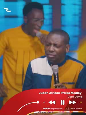 The image is a vertical shot featuring two Black men, both dressed in yellow long-sleeved shirts, in a performance or recording setting. The man in the front is holding a microphone close to his mouth and appears to be singing with his eyes closed, while the man behind him is singing into a microphone, his eyes open and focused. At the bottom of the image is a red graphic with audio controls and the text 'Judah African Praise Medley Dare David'.