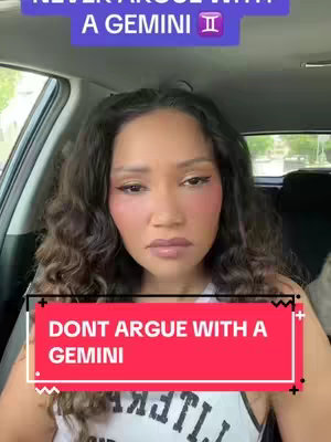 The cover image is a selfie featuring a woman in the front seat of a car, with her upper body visible from the chest up. She is looking at the camera with a serious expression. The background shows the car's interior, parts of the road and a tree in the distance. Added text overlays in purple and red banners say, "NEVER ARGUE WITH A GEMINI" and "DONT ARGUE WITH A GEMINI".