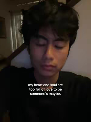 A medium shot features a young man with short, dark, tousled hair and a neutral expression. The background is softly lit, suggesting an indoor setting. Overlayed on the image is text in a clean, sans-serif font.
