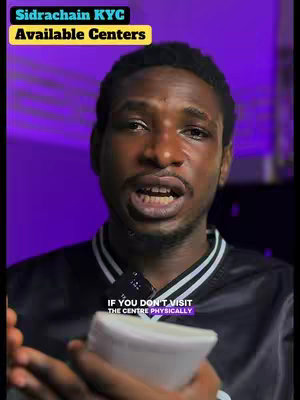 A man is centered in the frame, speaking directly to the camera, holding a white object. Above him, overlaid text in a yellow box reads 'Sidrachain KYC Available Centers'. Below, text in a purple rectangle says, 'IF YOU DON'T VISIT THE CENTRE PHYSICALLY'. The background has a gradient of purple hues.