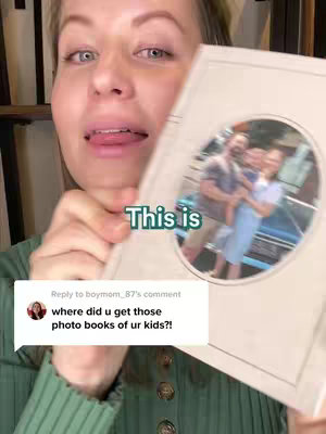A woman holds up a photo book, smiling and showing it to the camera. A text overlay reads "This is". A comment section from another user is also visible.