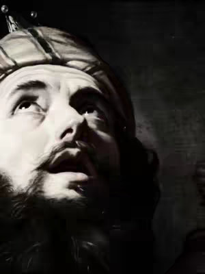 A black and white image features a man looking up with an open mouth, suggesting a call or prayer. He wears a turban-like head covering, sporting a mustache and beard, with the focus on his face and gaze.