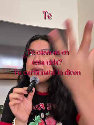 A woman is holding a microphone and gesturing with her hand. Overlay text in shades of red appears over the woman's face. The background is a TV screen.