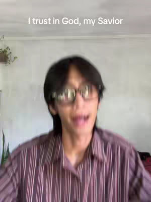 The cover image features a person, blurred due to motion or movement, against a background with a neutral color. The person appears to be of Asian descent, wearing glasses and a striped shirt. Text overlays reads 'I trust in God, my Savior'.
