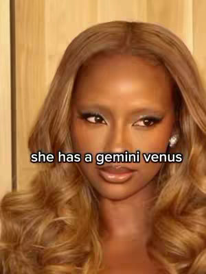 The cover image is a close-up portrait of a person with light brown skin, styled hair, and makeup. The person's hair is long, wavy, and a warm chestnut color. Their eyebrows are light and slightly arched. The person is adorned with a silver earring and a hint of blush, making her eyes pop. The text overlay reads: "she has a gemini venus"