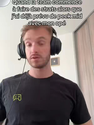 A man with short, light brown hair is wearing a black t-shirt and black headphones with a microphone. Text overlays above him in a sans-serif font in white.