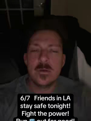 A selfie-style video. The main focus is on a man's face from the chest up, with a dark background. He has a mustache and a serious expression. Text is overlaid on the image.