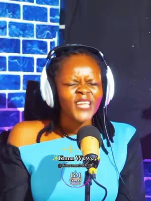 The cover image features a woman with dark skin singing passionately into a microphone while wearing headphones. The background is a blue brick wall, with a few sparkles adorning the top-right corner of the image. Text overlays at the bottom detail branding and handles.