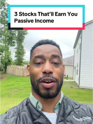 A selfie-style video with a man in a black quilted jacket, facing the camera. The background shows a green lawn, some trees, and a house with white siding, suggesting an outdoor setting.