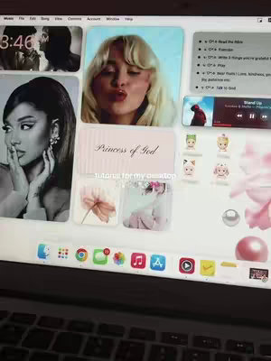 A desktop computer screen displays numerous aesthetic app icons and widgets, with a focus on a light pink theme. Prominent widgets include images of famous women and a prayer. The screen sits on a laptop with partially visible keyboard.