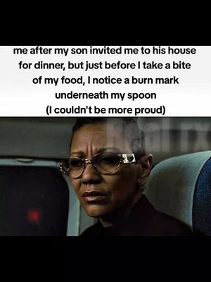 The image features a close-up of a Black woman with short hair, wearing thick-rimmed glasses. Her expression is a mixture of concern and slight bewilderment. Overlayed over the image is white text with black borders that speaks of a son. The image is in a dark setting, likely indoors, as indicated by the background and lighting.