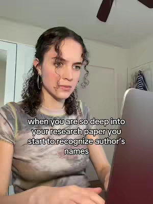 A young woman is shown in a close-up shot, looking down at a laptop screen as if she's deeply concentrating. She's wearing a patterned t-shirt and has curly brown hair. Text is overlaid on the image that seems to mirror the image's context and theme.
