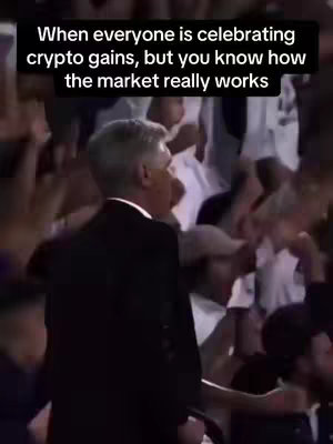An image from a crowded event, possibly a stadium or hall, where the focus is on a man in a black suit from the back with the surrounding people celebrating.