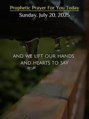 The image shows a close-up of water droplets hanging from a dark, slightly blurred object, likely a roof or awning. Underneath this, there is a soft, blurred green background, possibly foliage. In the foreground, a section of a brown wooden fence is visible. The image has text overlays in yellow and white, providing a message about prayer.