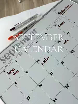 A photo of a monthly planner calendar with the month of September filled out with handwritten notes. Three pens lie on the left side, with Labor Day circled on the first Monday and highlighted text for other days. The title "SEPTEMBER CALENDAR" is written in a cursive font.