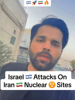 A selfie-style video cover featuring a man with a beard in an outdoor setting. Text overlays include flags and a headline about attacks and nuclear sites.