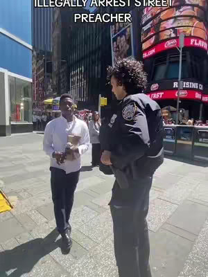 A street scene in a city with a man in a white shirt speaking to a person in a police uniform. A large sign is visible in the background.