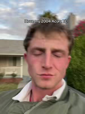 The cover image shows a man in a close-up shot with slightly blurred background. Text overlay reads, 'I love my 2004 Acura TL'. The man has fair skin, short brown hair, and is wearing a green jacket over a white collared shirt. The background of the image shows a house and some greenery. The focus is on the man's face and upper body.