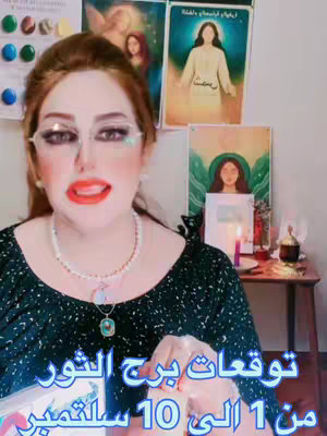 A woman with red hair, glasses, and bright red lipstick is centered in the image, with text overlays in Arabic at the bottom. She is wearing a dark green top and a beaded necklace. In the background are framed images and candles.