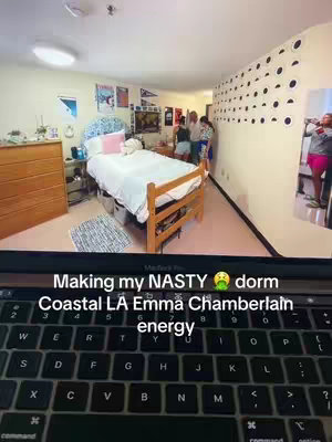 A laptop displays a dorm room scene; the room is messy but has a lively, bright aesthetic. The keyboard is visible providing context.
